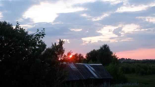 Rural landscape with field at sunset and village in the background Vologda region