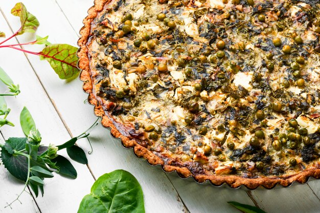 Rural pie with swiss chard, feta cheese and green peas. Pie with herbs, proper nutrition.