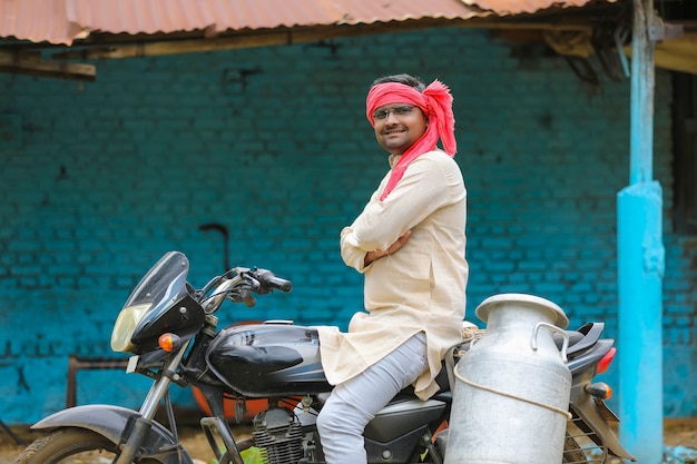 Rural scene : indian milkman distribute milk on bike