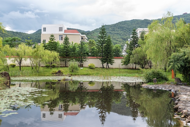 雨上がりの田園風景、家、緑豊かな山々、川