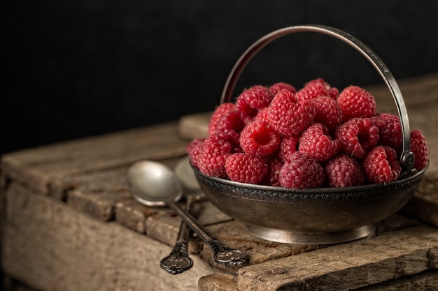 Rural still life with raspberries on rustic table.