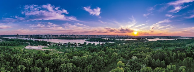 写真 ドニエプル川と劇的なカラフルな空の自然背景の空中写真とキエフの田舎の夏の夕日素晴らしい季節の風景のパノラマ