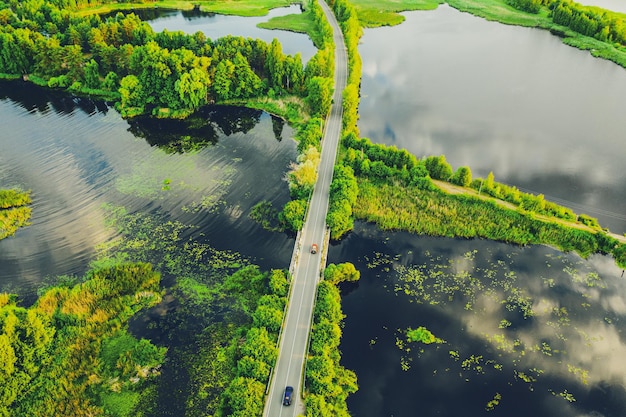 Rural summer sunset landscape with lake and road, natural background, aerial view