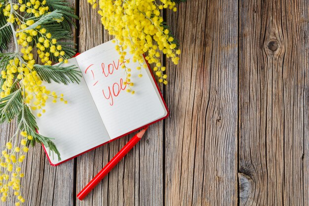 Rural wooden table with notebook and love message