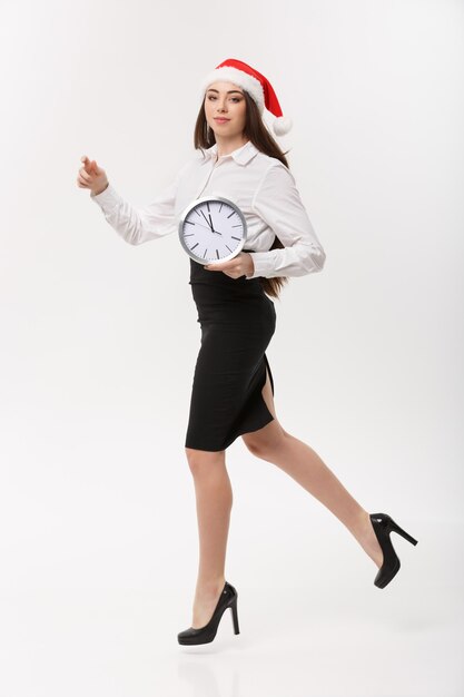 Rush time concept - bella giovane donna caucasica in esecuzione con orologio isolato su bianco.