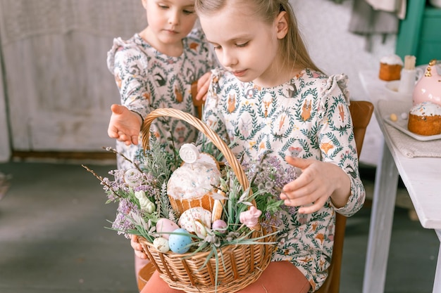 Rusland Moskou 04092022 prettige paasvakantie tijd in het voorjaar seizoen familie en kleine kinderen zusters houdt mand met beschilderde eieren en pasen gebakken taarten feestelijk huisdecor traditioneel eten