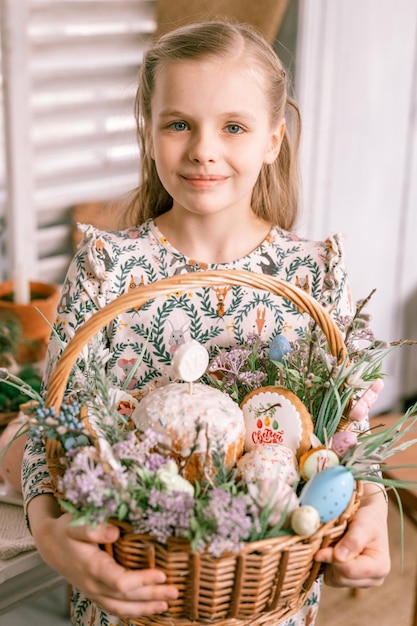 Russia Moscow 04092022 happy easter holiday time in spring season little eight year old kid girl holds basket with painted eggs and easter baked cakes festive home decor traditional food