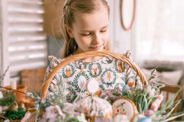 Russia Moscow 04092022 happy easter holiday time in spring season little eight year old kid girl holds basket with painted eggs and easter baked cakes festive home decor traditional food