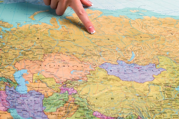 Russia on the world map. Woman&amp;#39;s finger pointing at Russia. Biggest slavic country. Giant of the world economy.