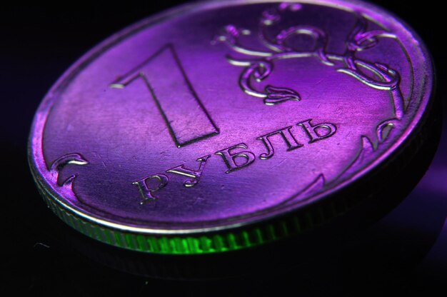 Монета 1 рубль России подсвечивается пурпурным светом. крупный план.