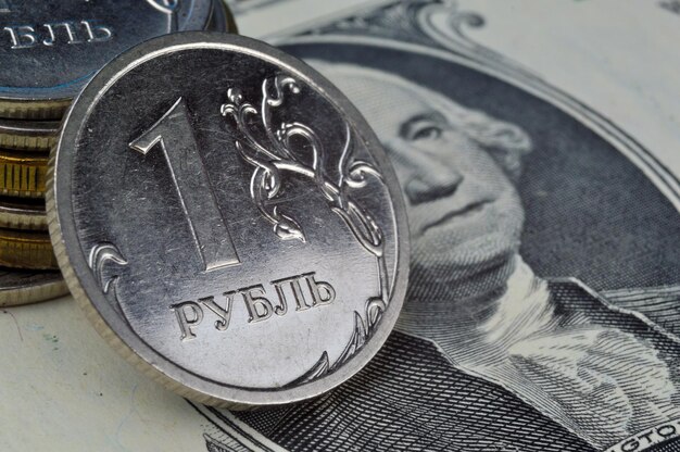 Russian 1 ruble coins lie on an American 1 dollar banknote