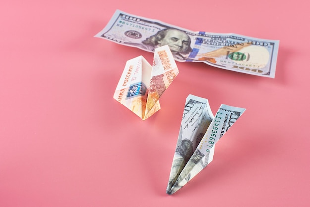 Russian and American paper money on a pink background. The concept of growth of the dollar and the fall of the ruble