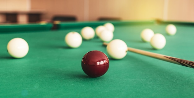 Russian billiard table with balls and cue sticks.