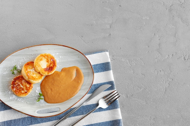 Russian cheesecakes served on plate with sweet sauce