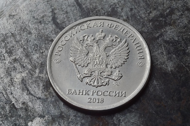 Russian coin with a face value of 1 ruble lies on a dark metal surface closeup