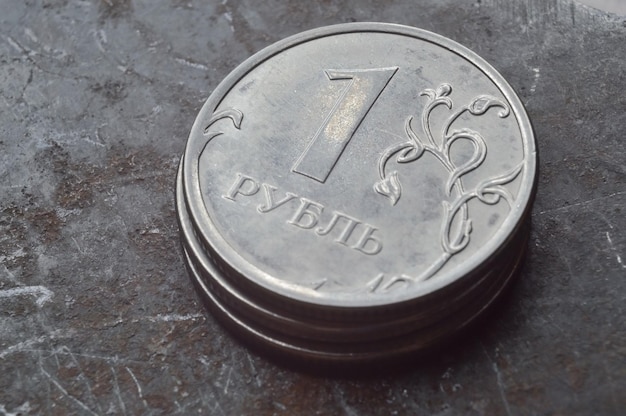 Russian coin with a face value of 1 ruble lies on a dark metal surface closeup