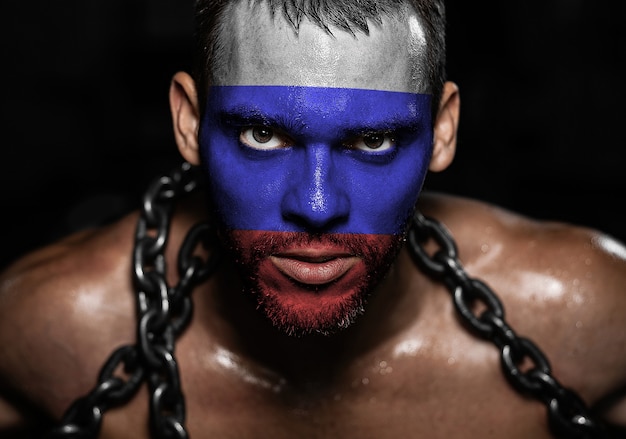 Russian flag on the face of a young man