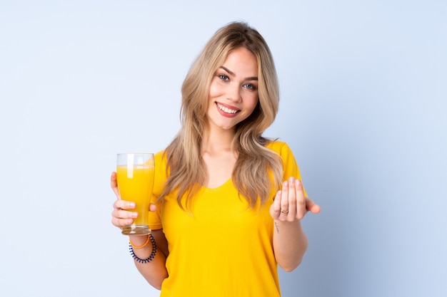 Russian girl holding an orange juice inviting to come with hand