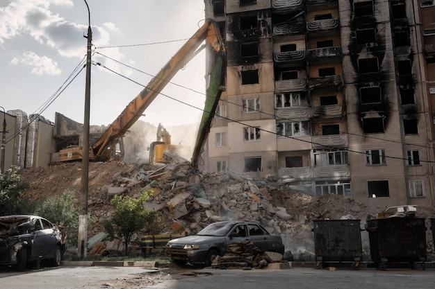 russian invasion of ukraine demolishing process of residential building bulldozers dismantle the rubble of a house destroyed by russian army