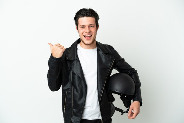 Russian man with a motorcycle helmet isolated on white background pointing to the side to present a product