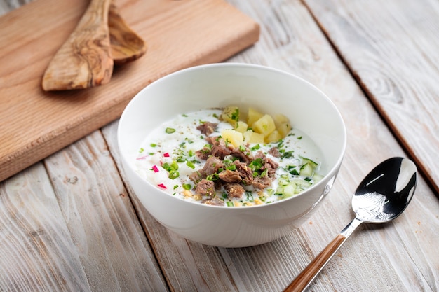 Zuppa fredda russa okroshka con carne di manzo e verdure sul tavolo di legno