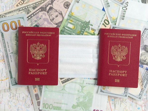 Russian passports are on the map of the city and between them is a medical mask. The concept of a journey during a pandemic