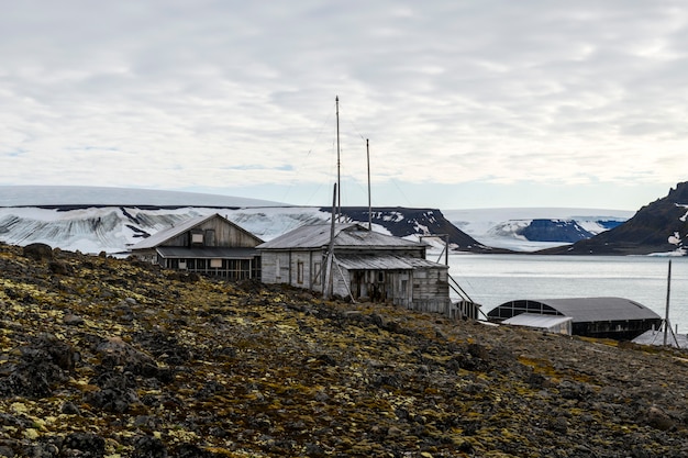 Foto base russa di ricerca e spedizione polare nella baia di tikhaya (tikhaya bukhta) nell'arcipelago di franz josef land. edifici in legno nell'artico.