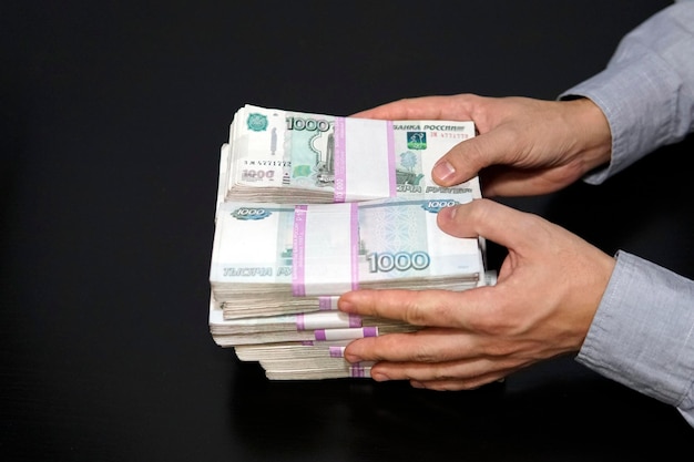 Russian rubles in bundles on the table million rubles businessman holding a lot of money Money financial business concept