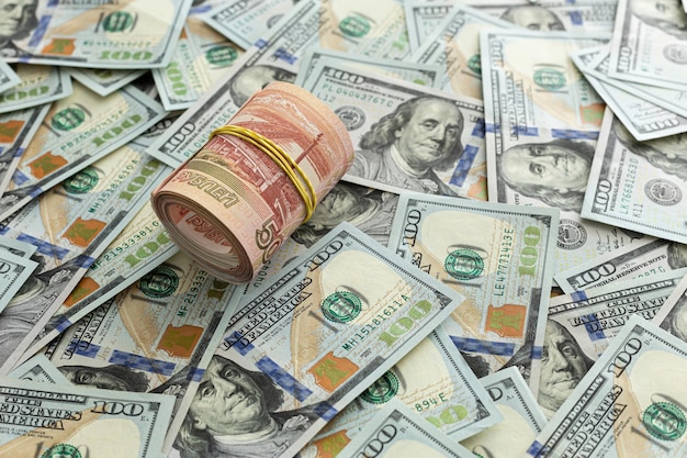 Rubli russi in contanti giacciono su una pila di banconote da cento dollari 5000 rubli 100 dollari