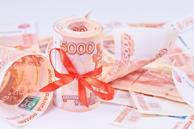 Российские рубли пять тысяч банкнот пачка денег с красной лентой на белом фоне концепция подарка