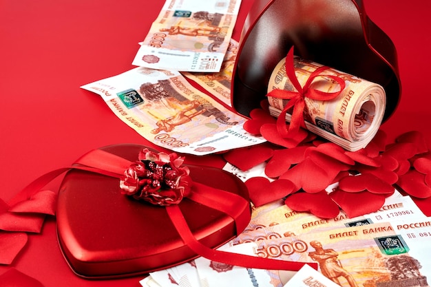 Russian rubles on red background bundle of five thousand banknotes with red ribbon in heart box money gift concept