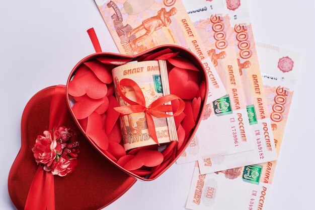 russian rubles on white background bundle of five thousand banknotes with red ribbon in heart box money gift concept