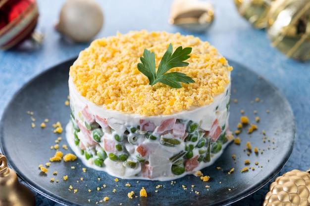 Russian salad or Olivier salad for Christmas dinner on blue surface