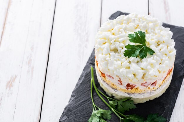 Russian salad or Olivier salad for Christmas dinner on wooden table