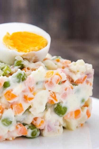 Russian salad on a rustic wooden table