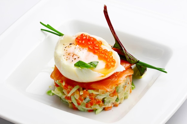 Russian salad with salmon and red caviar on wight