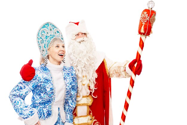 Foto babbo natale russo con uno staff con una fanciulla di neve sorridente e guardando in lontananza. isolato su sfondo bianco. spazio per il testo.