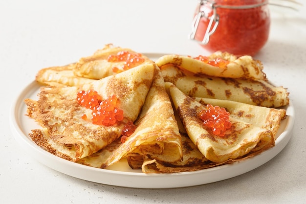 Russian thin pancakes or blini with red caviar