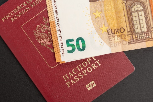 Russisch buitenlands internationaal paspoort en euro op een zwarte achtergrond