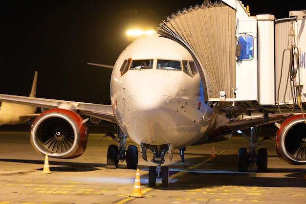 Russisch vliegtuig van Rossiya Airline met jetway op de luchthaven's nachts