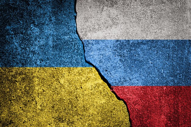 Russische en Oekraïense vlaggen met een barst op de achtergrond van beton