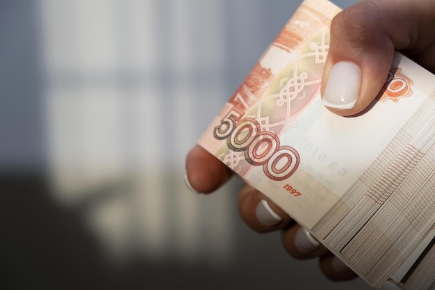 Russische geldroebels Vijfduizendste bankbiljetten contant Een stapel geld in een vrouwelijke hand met een Franse manicure