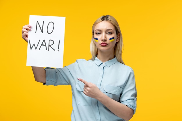 Russische Oekraïense conflict schattig meisje gele achtergrond met Oekraïense vlag op wangen ondertekenen geen oorlog
