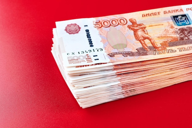Russische roebels vijfduizendste bankbiljetten stapel geld op rode achtergrond