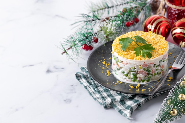 Russische salade of Olivier salade voor kerstdiner op marmeren achtergrond