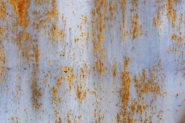 Rusted flat solid sheet metal surface background and texture with leftovers of white and light blue paint