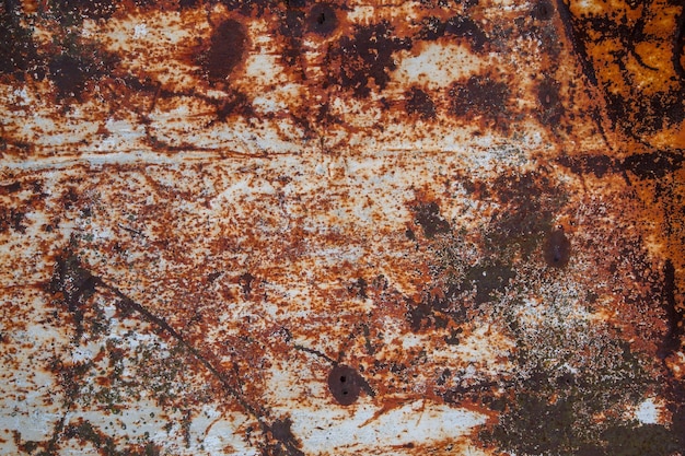 Photo rusted flat solid sheet metal surface background and texture with leftovers of white paint vertical orientation