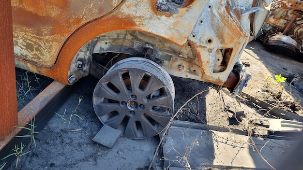 A rusted out car with a wheel on it