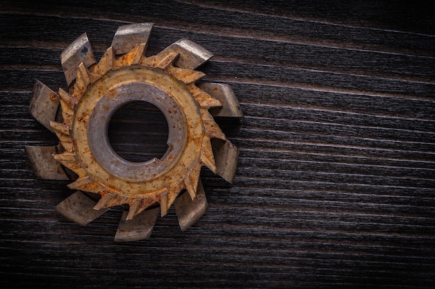 Rusted rotary cutter on vintage wooden board construction concept