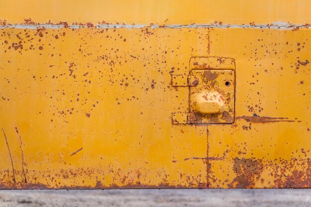 Rusted yellow bus board with small hatch